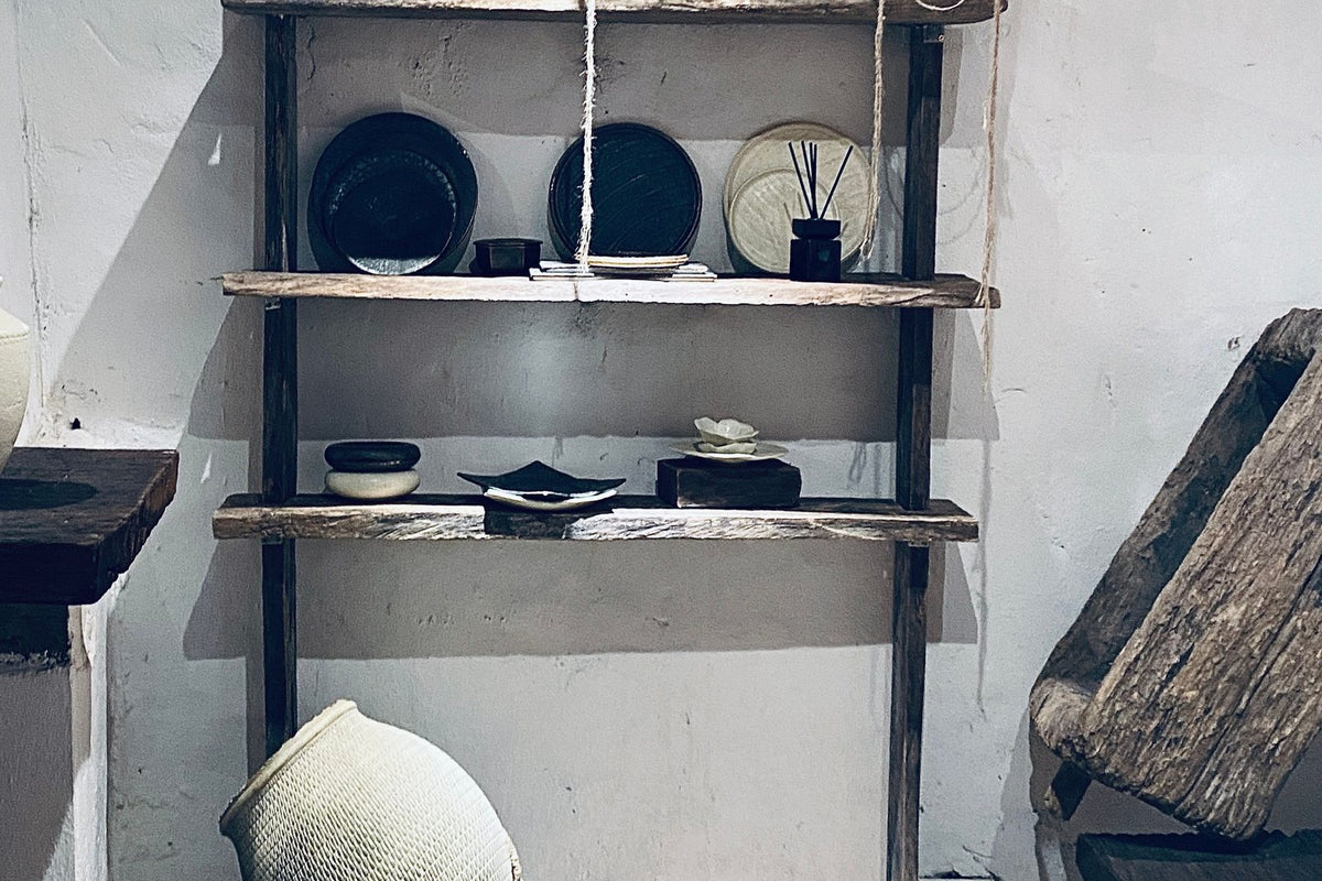 Beyaz niş ve raflarda seramik kaplar, kitaplar ve doğal dokulu objeler