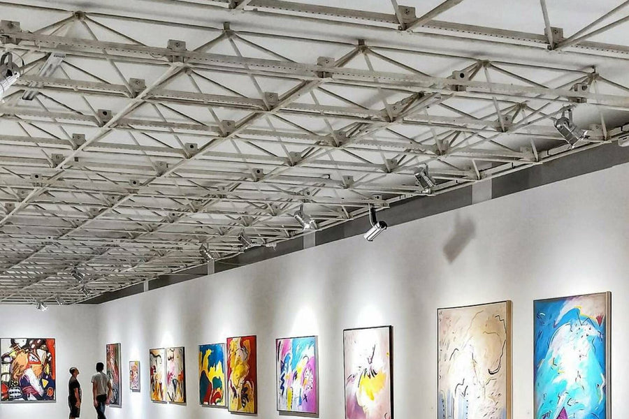Çelik tavanlı büyük çağdaş sanat fuarı veya galeri alanında renkli eserler